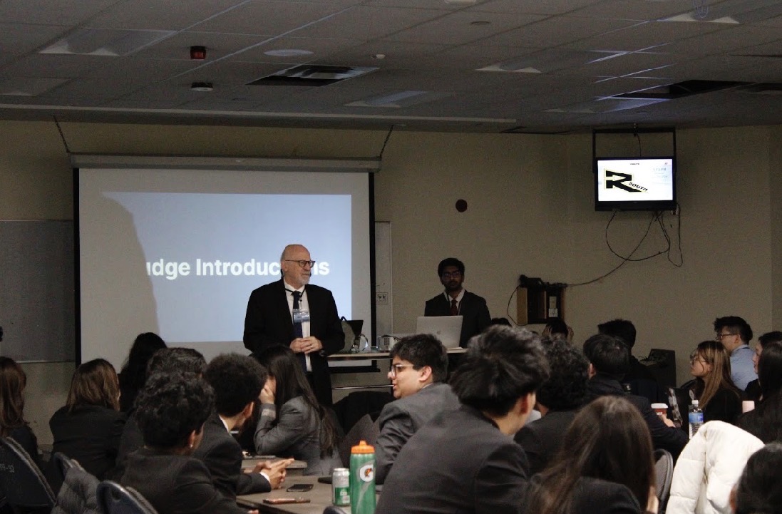 A judge speaking with students at INSPIRE