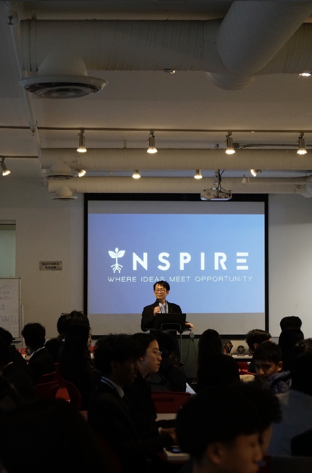 A speaker presenting from the INSPIRE podium