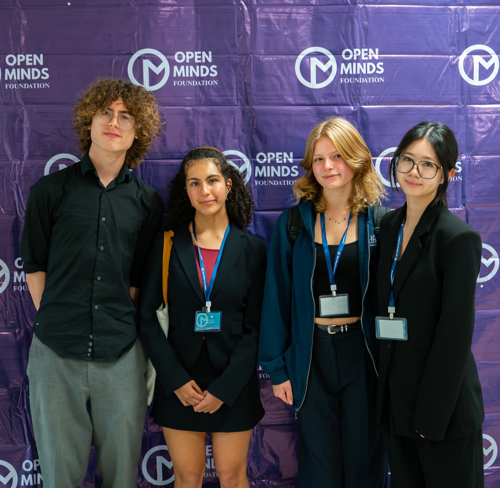 Four Velocity participants together in front of an Open Minds Foundation backdrop
